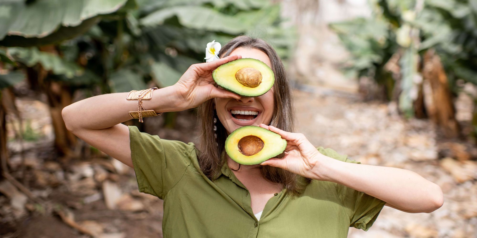 Healthy Woman holding a magnesium rich food, an avocado!