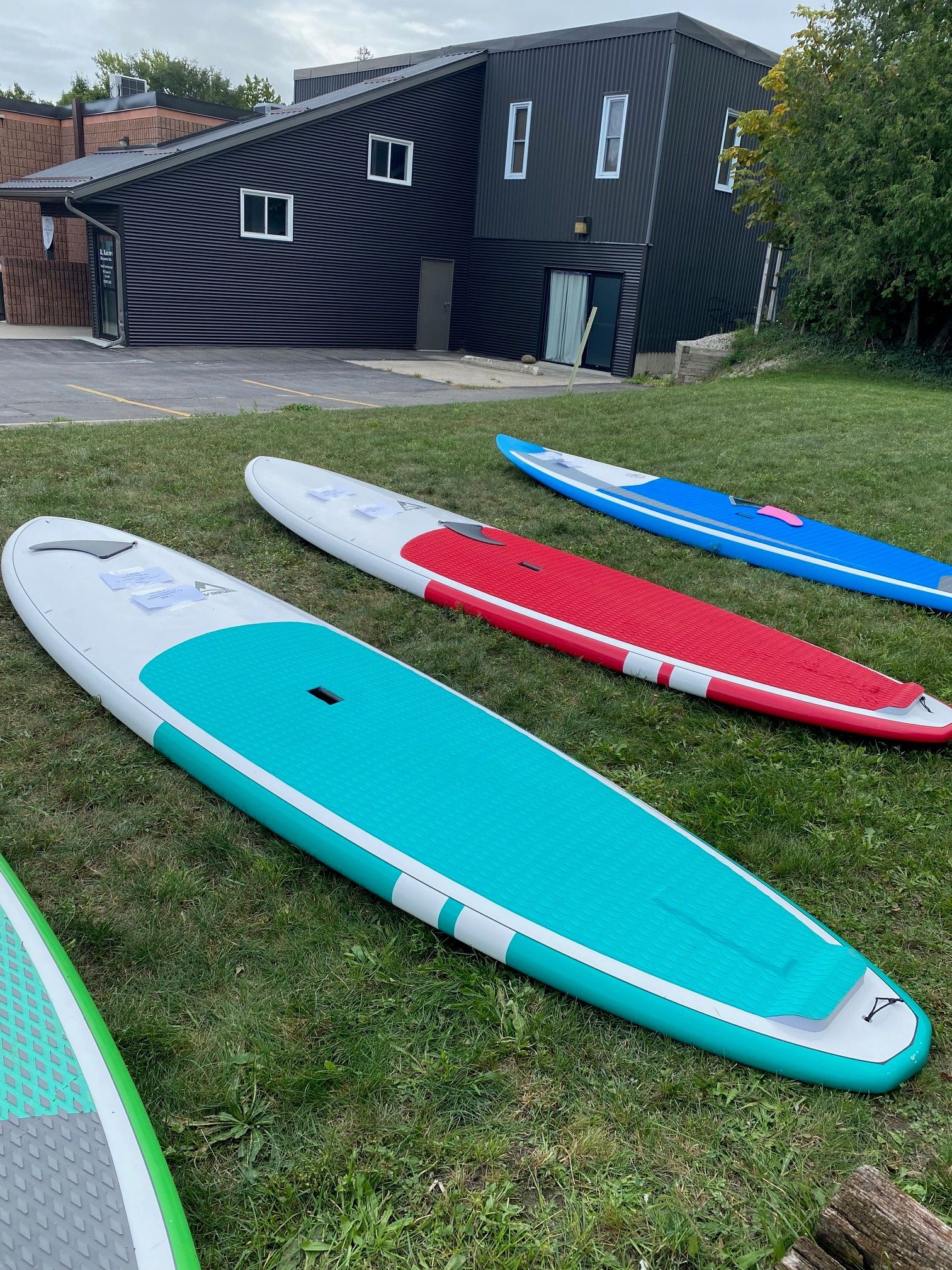 Paddle boards laid out on grass for sale 