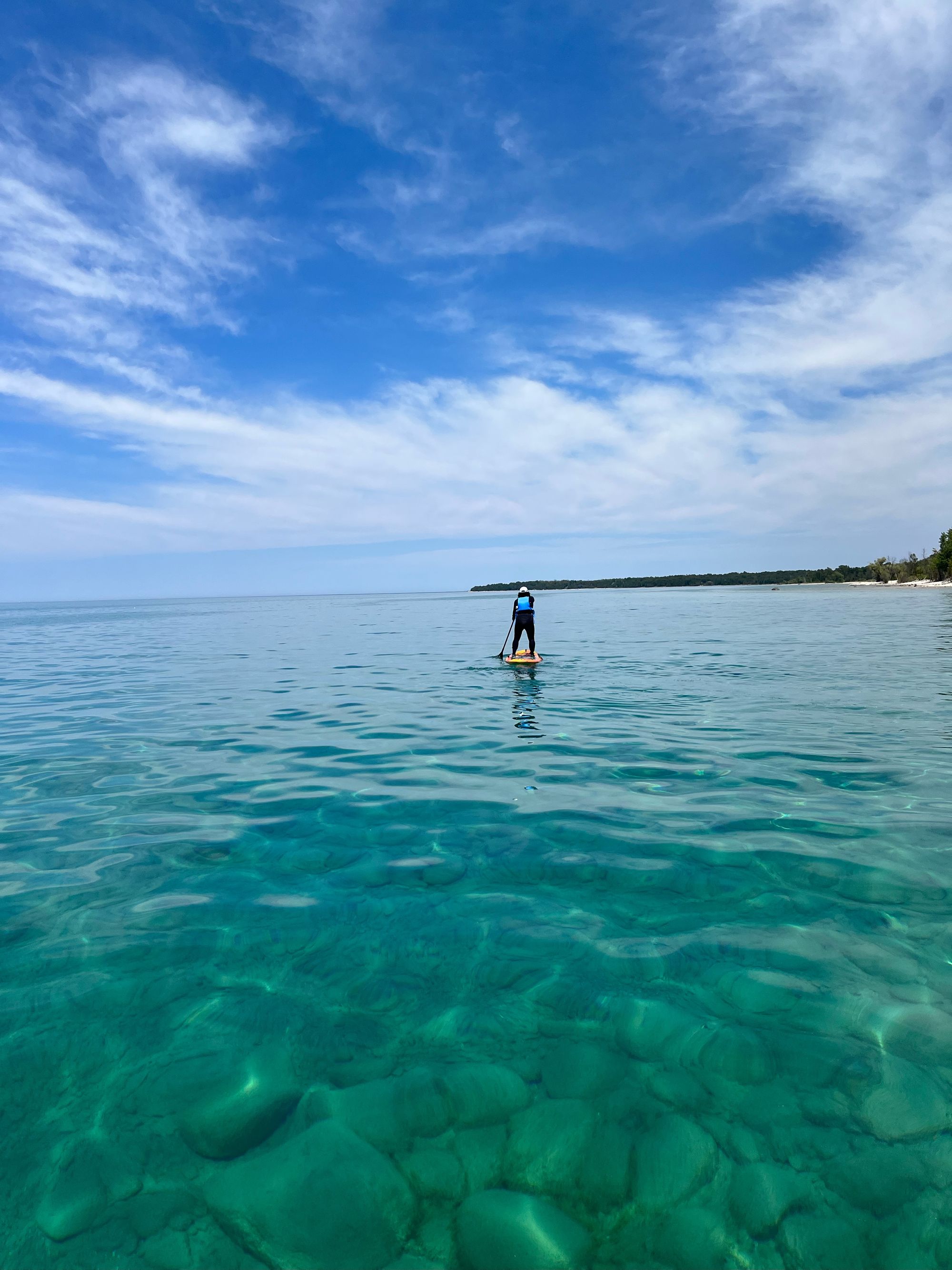 Woman wearing PFD on paddle board in Lake Huron