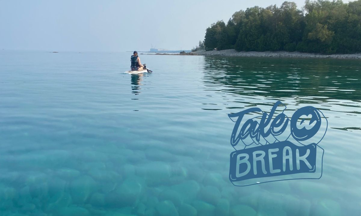 Paddleboarder taking a break on large lake