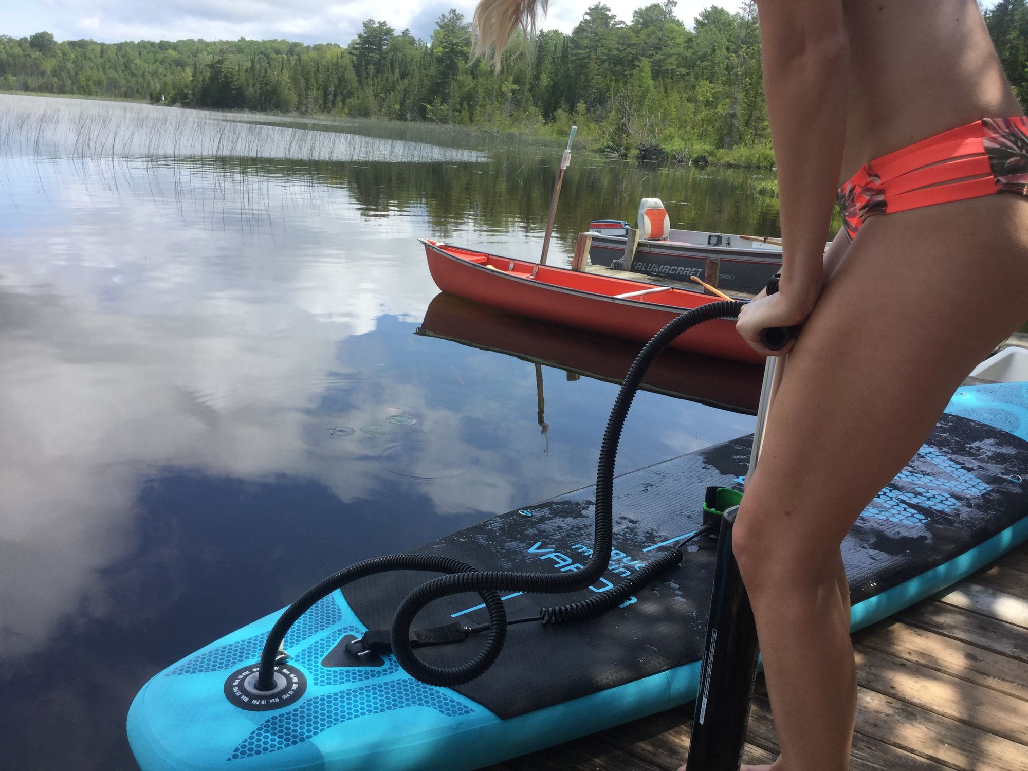 Young woman inflating an Inflatable Paddle Board 