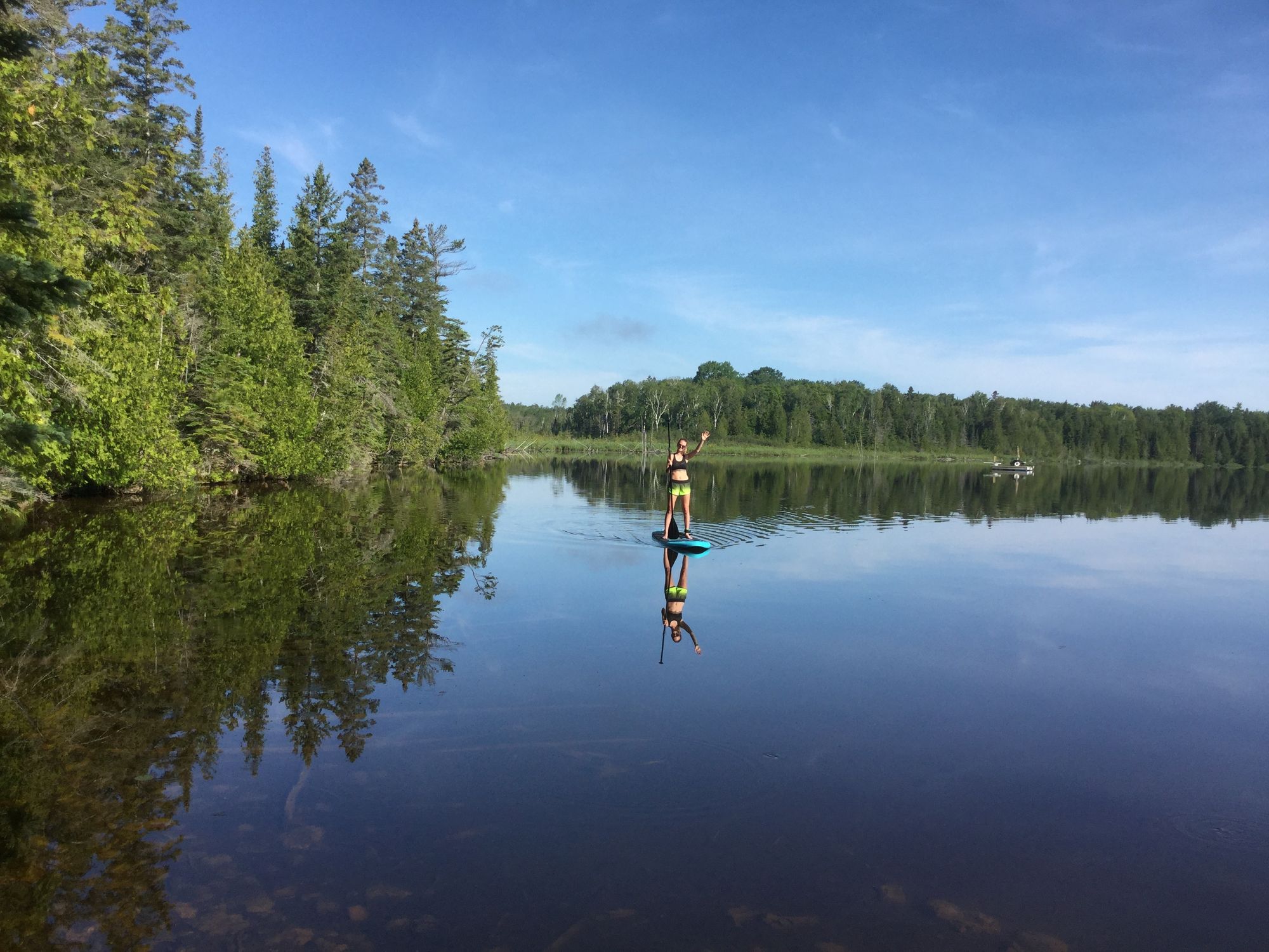 Young woman on inflatable paddle board on calm lake