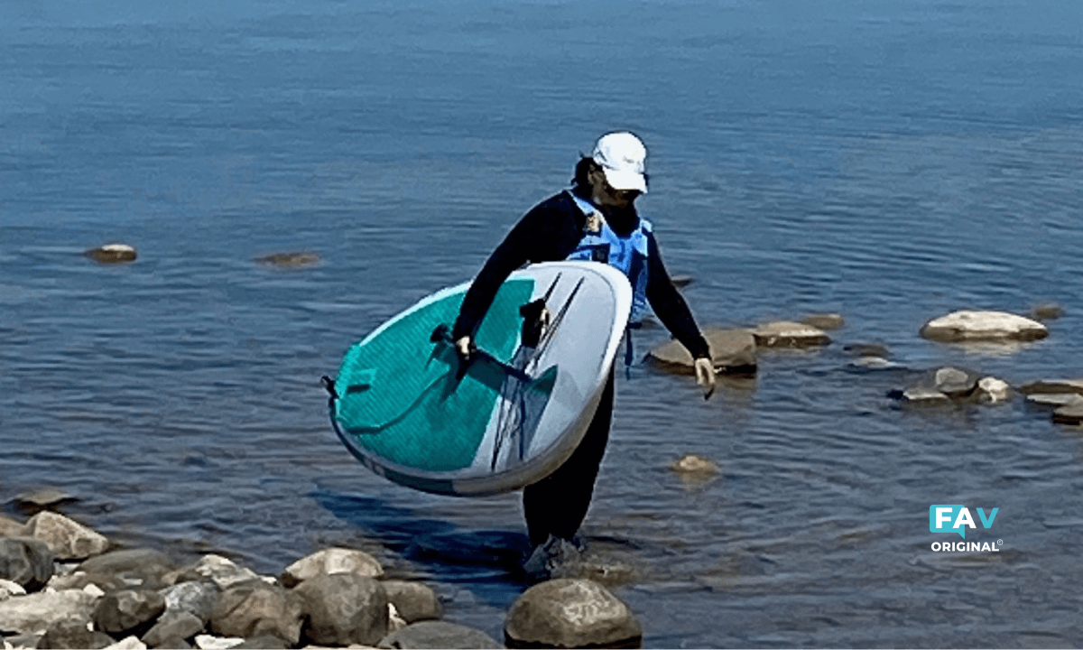 Deborah Clarke, carrying Adventure All Rounder MX Paddle Board out of Lake Huron.