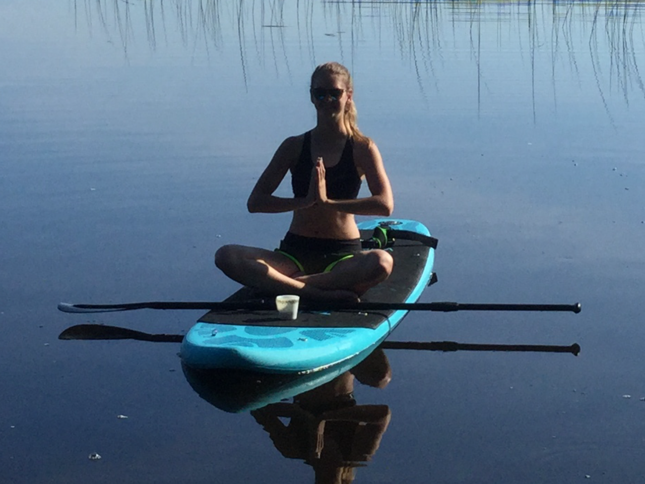 Inflatable budget paddle board with young lady having morning coffee