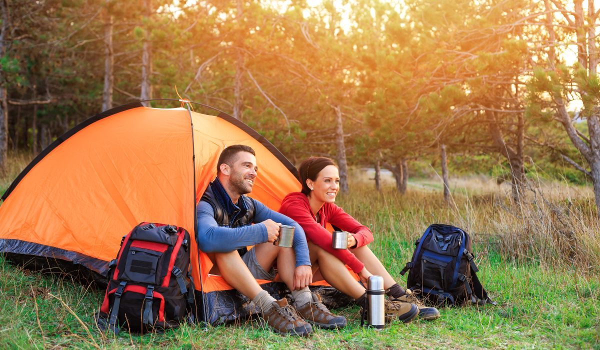 Couple having morning coffee while camping