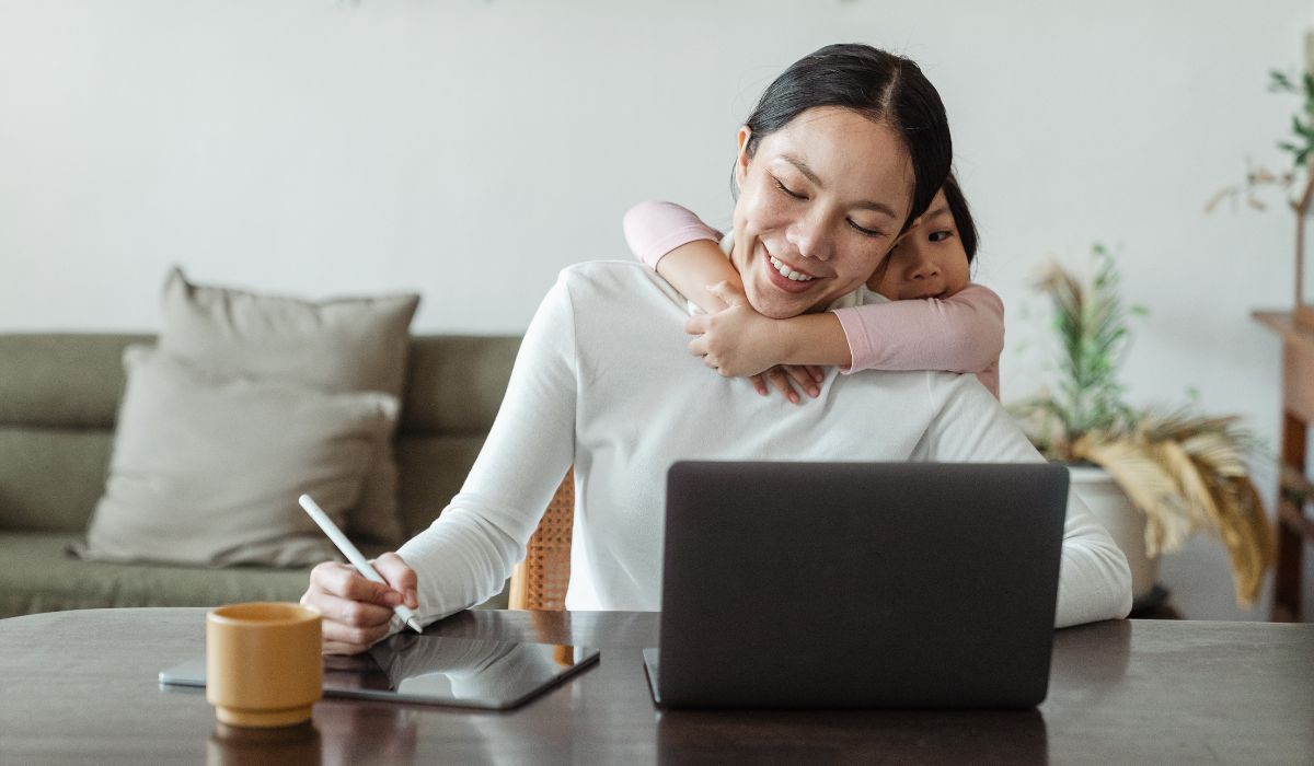 Work from home no phones | Mother working on laptop with daughter hugging her