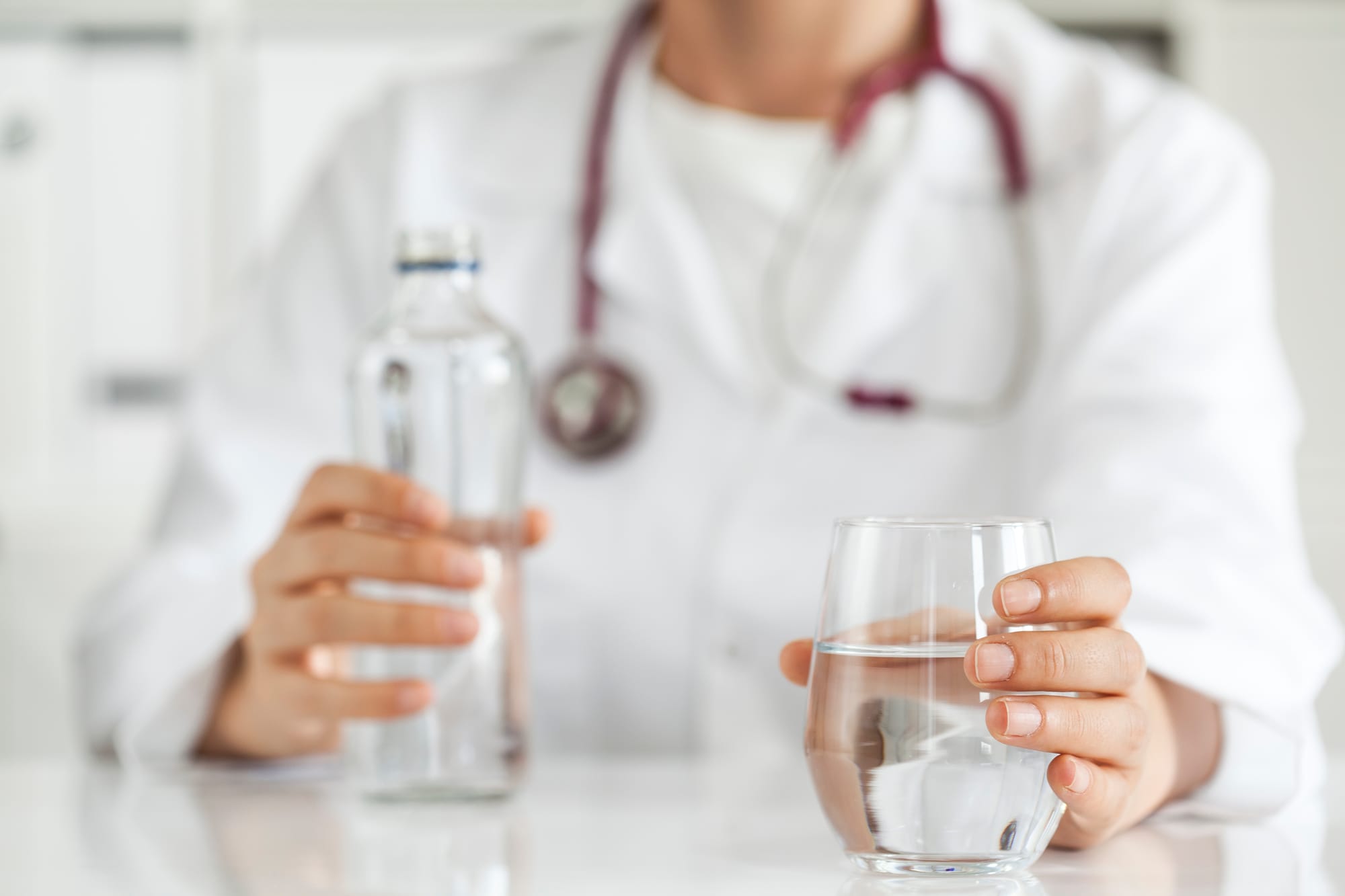 Nurse staying hydrated with water bottle on the job.