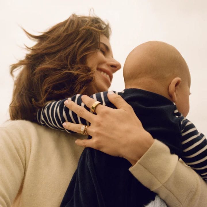 Easy to wear, the Oura Ring being worn by a mom carrying baby.